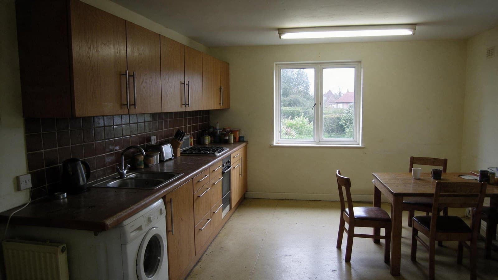 Before: A dark galley kitchen, opened to the garden