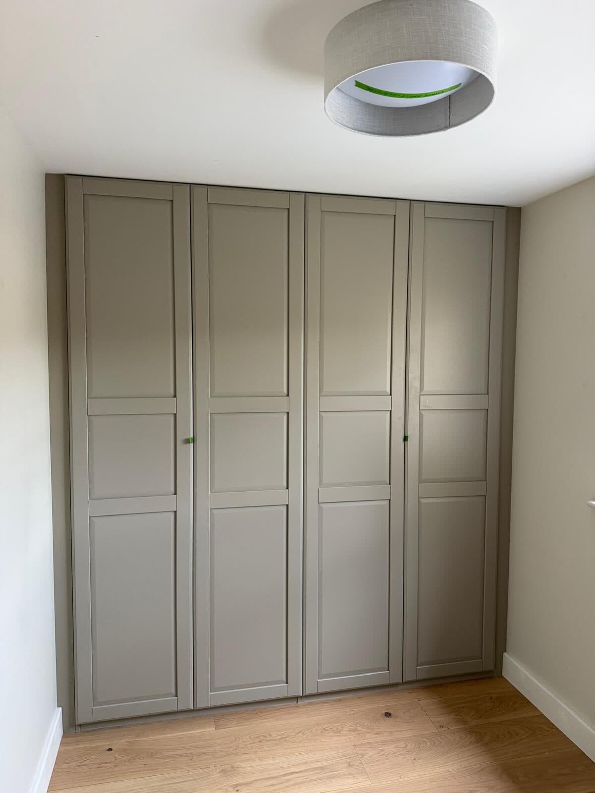 Full-height cupboards taken to the ceiling and painted to match the run, so the room reads as one piece.