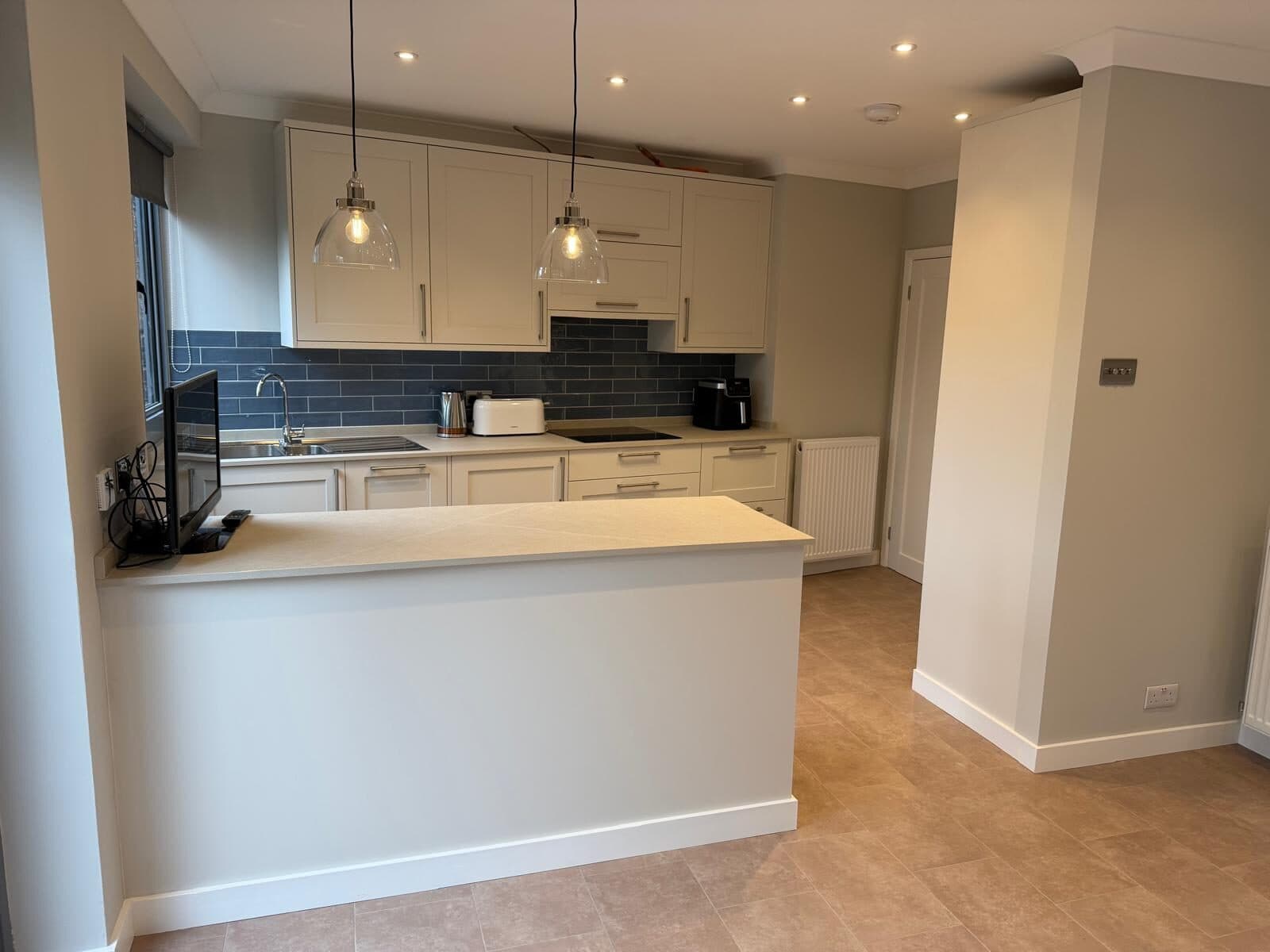Kitchen island with pendants and a tiled splashback